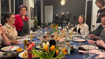 Gruppe beim Essen an festlich gedecktem Tisch.