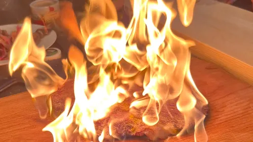 Steak flammend, Holztisch-Hintergrund.