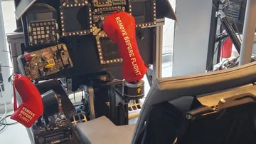 Cockpit with red safety covers, control panels.