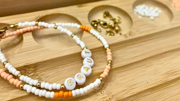 Perlenarmband auf Holztablett liegend.