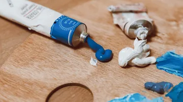 Farbentuben auf einer Holzpalette gedrückt.