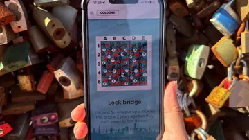 Hand holding phone displaying lock bridge puzzle.