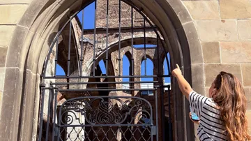Person pointing at historic church ruins.
