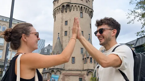 Zwei Personen geben High-Five vor einem Turm.