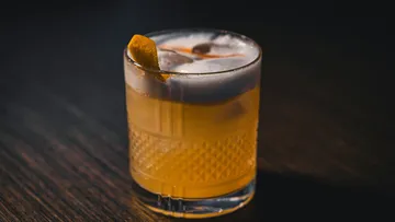 Whiskey sour cocktail on dark table.