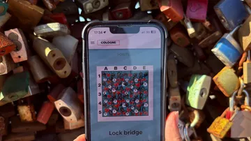 Smartphone zeigt Puzzle, umgeben von Vorhängeschlössern.