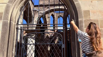 Person zeigt auf historische Kirchenruine.