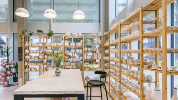 Pottery displayed on shelves in bright studio.