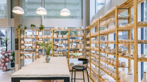 Pottery displayed on shelves in bright studio.