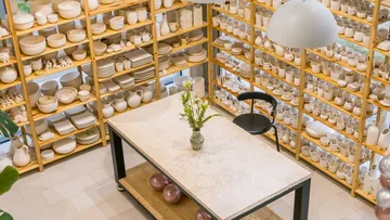 Ceramic dishes on shelves surrounding table.