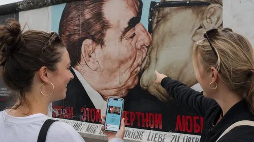 Women admire and point at famous mural.