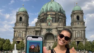 Frau hält Handy vor Dom.