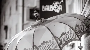 Decorative umbrella hangs beside a building.
