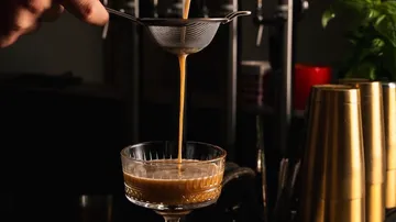 Cocktail being strained into a glass.