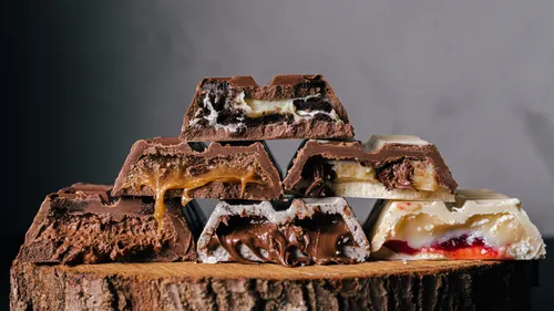 Chocolate bars with fillings on wooden surface.
