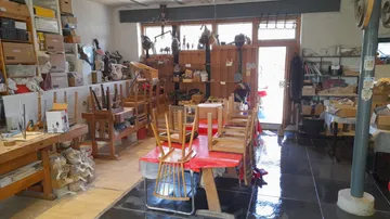 Stühle auf Tisch im Werkstatt gestapelt.