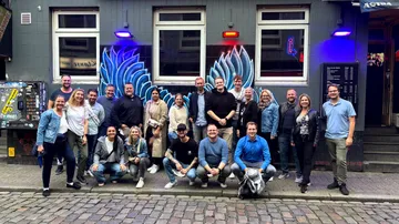 Group of people posing outside a bar.