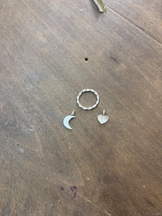 Jewelry charms placed on wooden table.