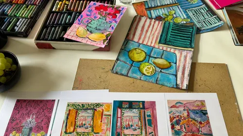Art supplies on table with colorful drawings.