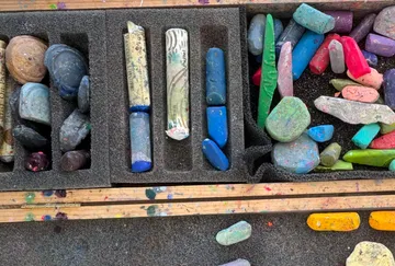 Bunte Kreidestücke in Schaumstoffhalterungen organisiert.