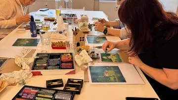 Personen malen Kunst an einem Tisch.