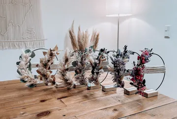 Blumenkränze auf einem Holztisch arrangiert.