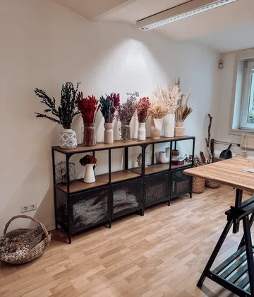 Shelf with vases and dried flowers displayed.