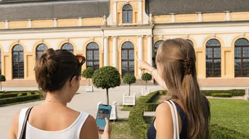 Zwei Frauen betrachten ein historisches Gebäude.