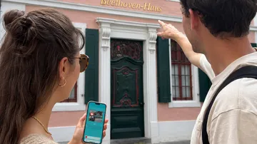 Two people observing Beethoven-Haus facade.