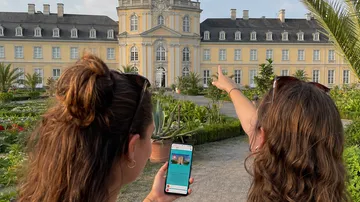 Zwei Personen betrachten ein historisches Gebäude.