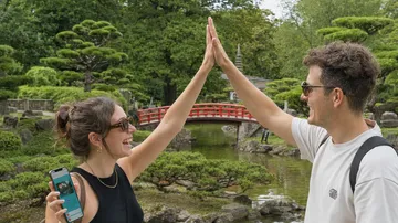 Zwei Personen geben sich High-Five im Garten.