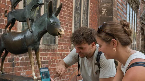 Zwei Personen betrachten Bremer Stadtmusikanten-Skulptur.