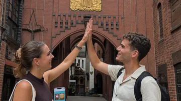Zwei Personen geben sich High-Five im Backstein-Tor.