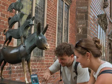 Statue gestapelter Tiere mit zwei interagierenden Personen.