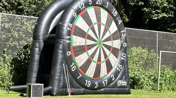 Riesige aufblasbare Dartscheibe auf Rasenfläche.