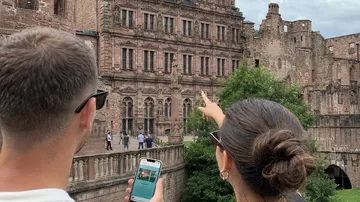 Zwei Personen betrachten historische Schlossfassade.