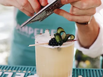 Ein Cocktail wird mit einer Reibe dekoriert.