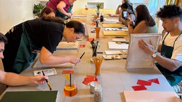 Menschen malen an einem Workshop-Tisch.