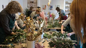People crafting wreaths in a workshop.