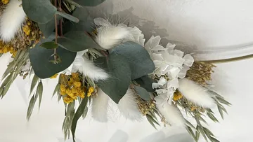 Floral wreath with eucalyptus on wall.