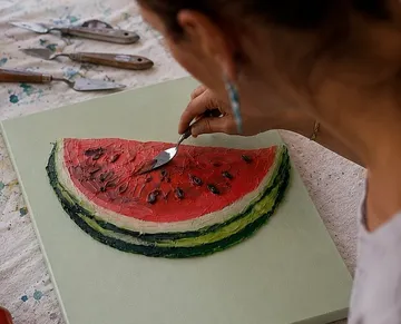 Artist painting watermelon slice canvas.