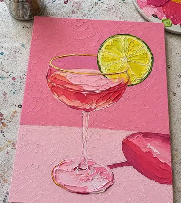 Gemälde eines Cocktails mit Limette auf pinker Leinwand.