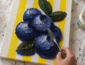 Palette knife paints blueberries, striped canvas.