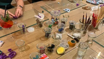 Hands crafting with clay at a table.