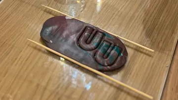 Clay with imprint on wooden table.