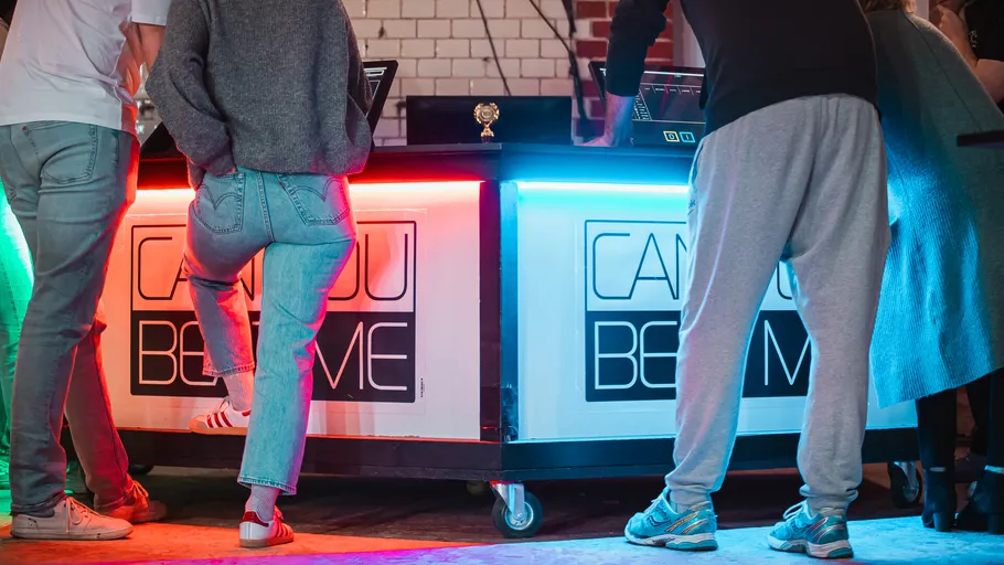 People standing at a colorful lighted table.