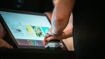 Person using touchscreen at digital kiosk.