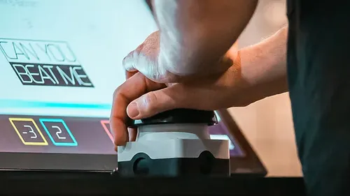 Hand pressing button on gaming console.