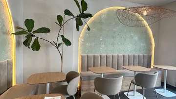 Café-Innenraum mit Wandkunst und Pflanzen.