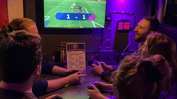 Group playing video game at a bar.